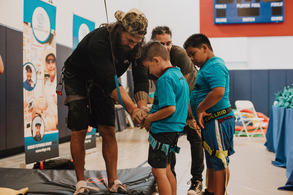 Jason Momoa and Dave Chancellor help LA Variety Boys and Girls Club members with their harnesses.